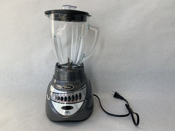 Blender pitcher on a kitchen counter with unblended fruit and ice inside