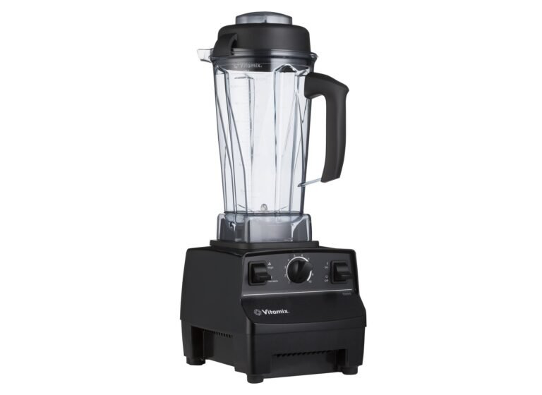 Clear blender container standing beside a white Vitamix 5000 motor base