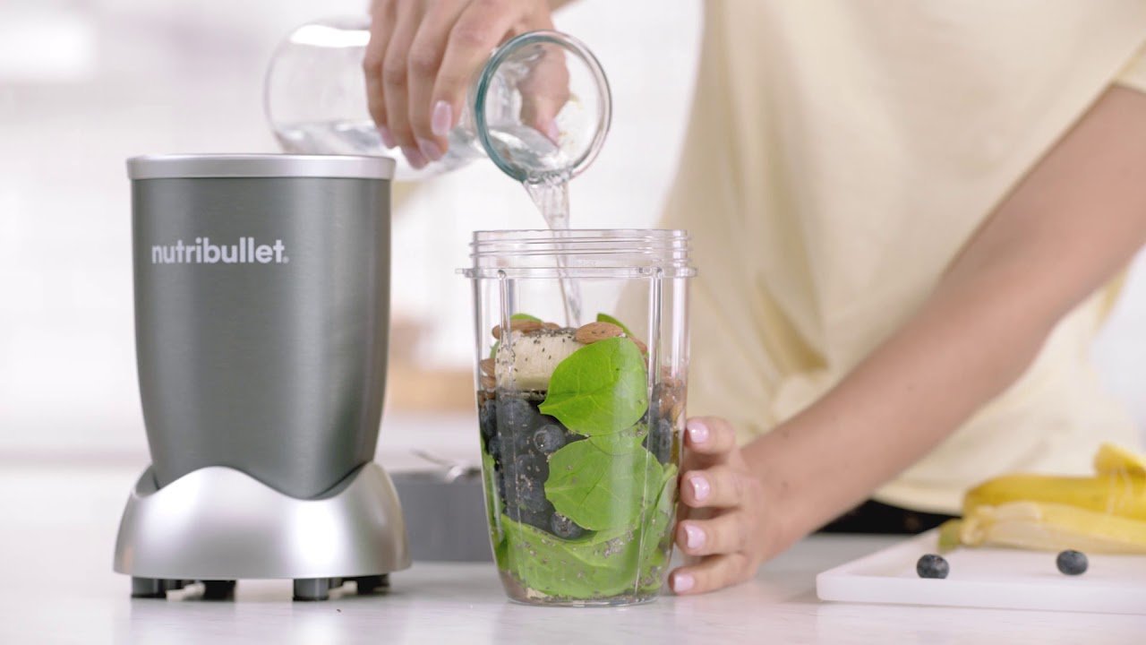 Countertop blender filled with fresh fruit and vegetables on a kitchen counter