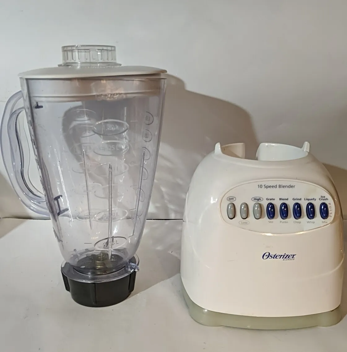 Damaged blender base and cracked jar beside an immersion blender