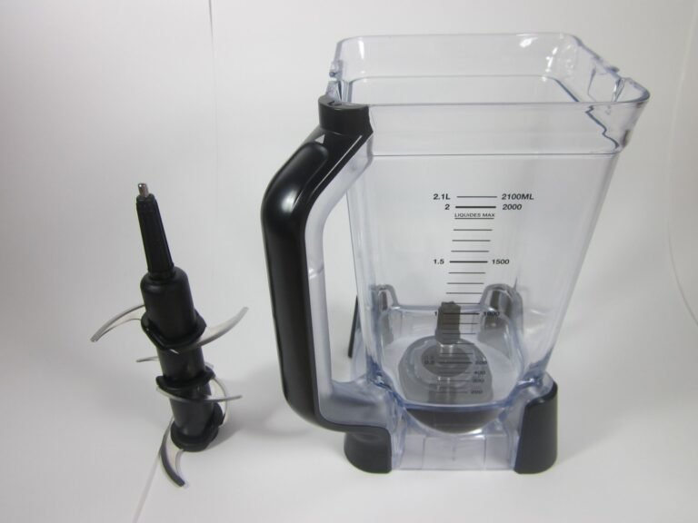 Disassembled Ninja blender components neatly arranged on a bright, clean kitchen countertop.