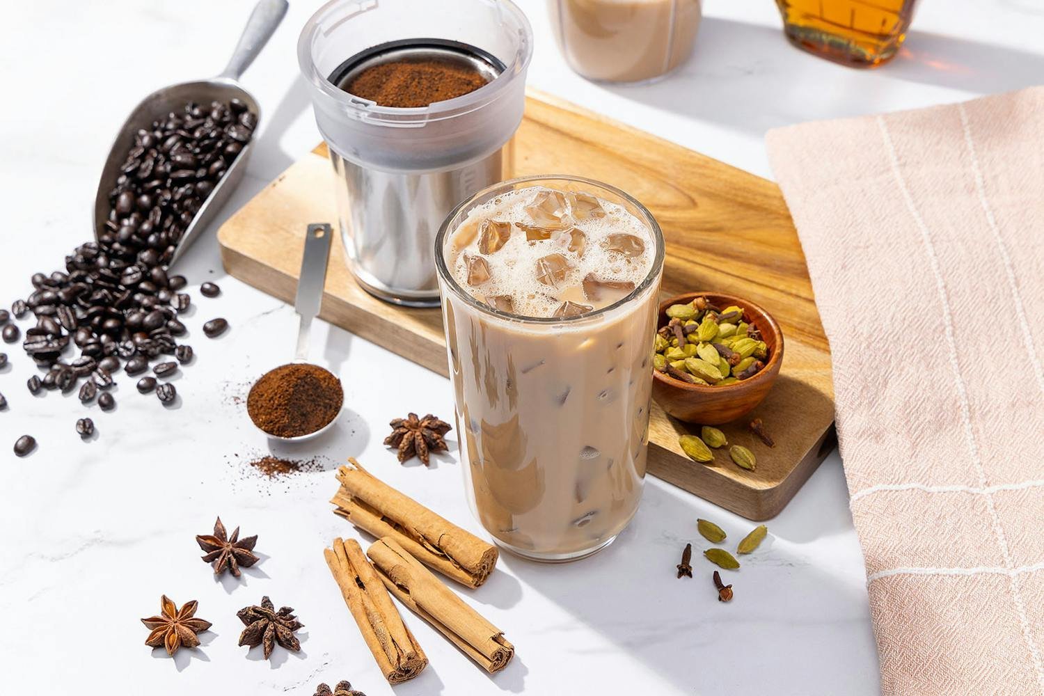 Empty personal blender beside a steaming mug of hot coffee on a kitchen counter