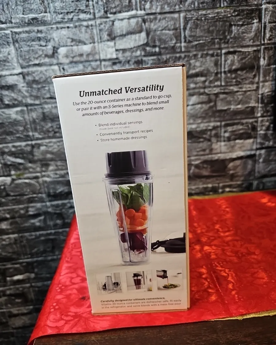 Empty Vitamix container beside a mini food processor and mortar and pestle on white quartz
