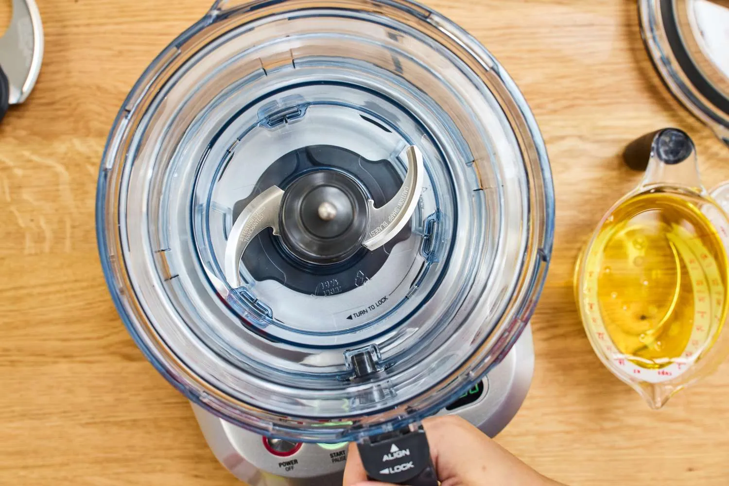 A fresh green smoothie being poured from a high-speed blender in a kitchen.