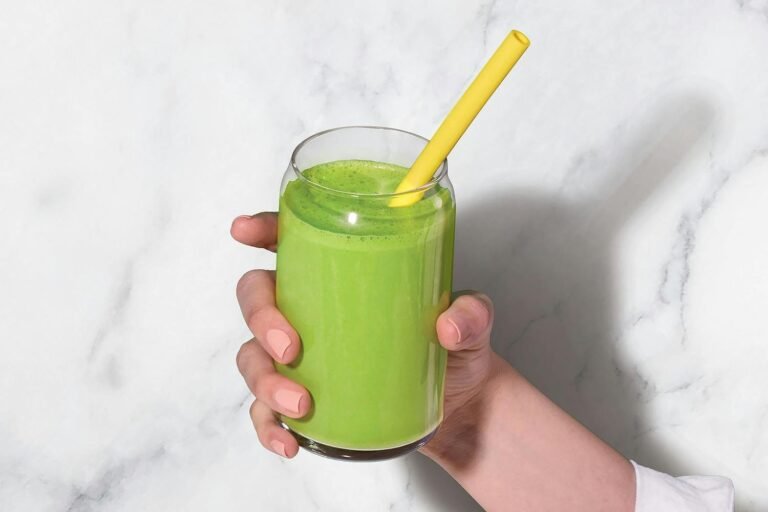 Green smoothie in a personal blender cup on a kitchen counter