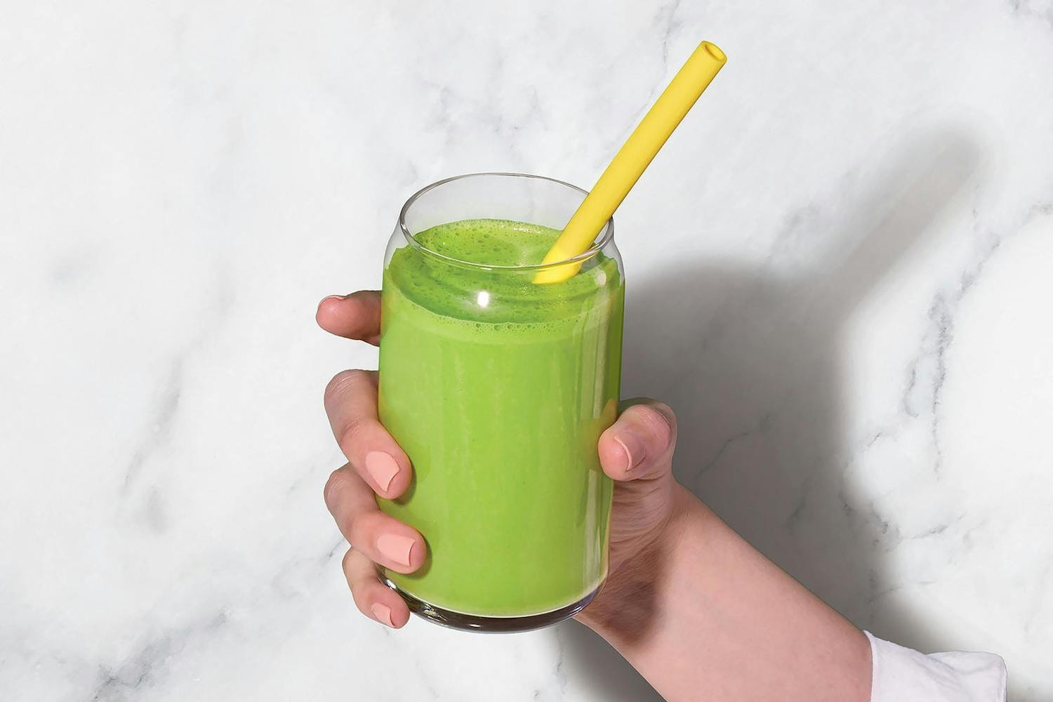 Green smoothie in a personal blender cup on a kitchen counter