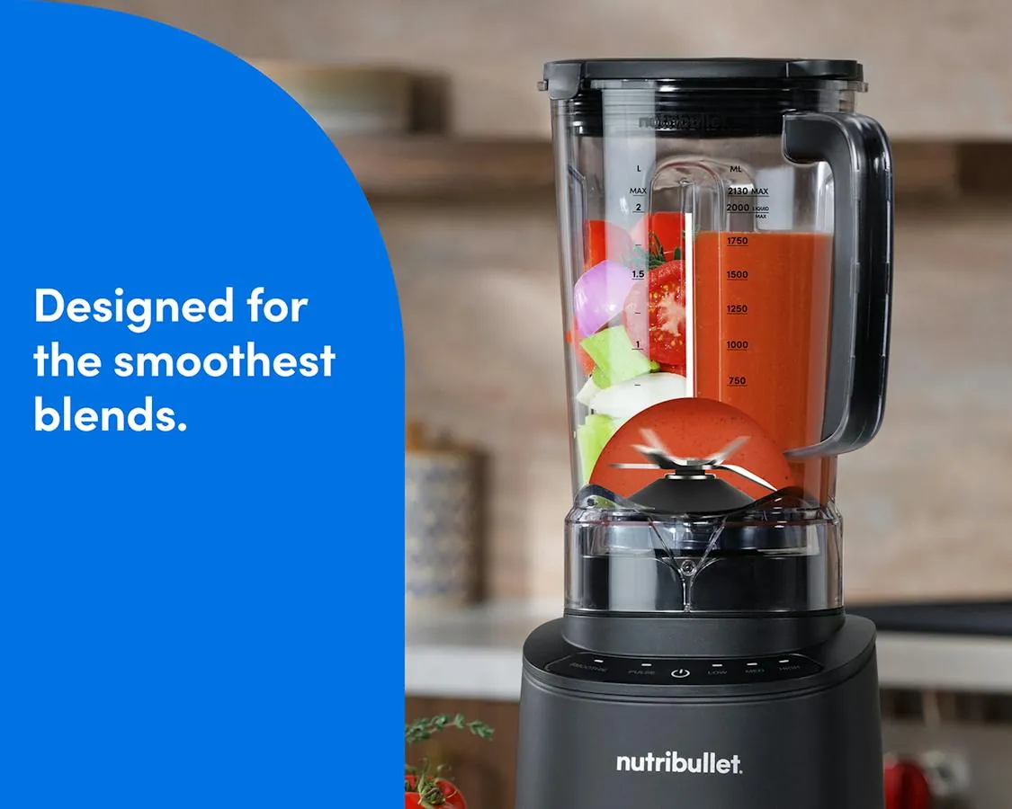 Hand checking warmth above a blender cup of soup
