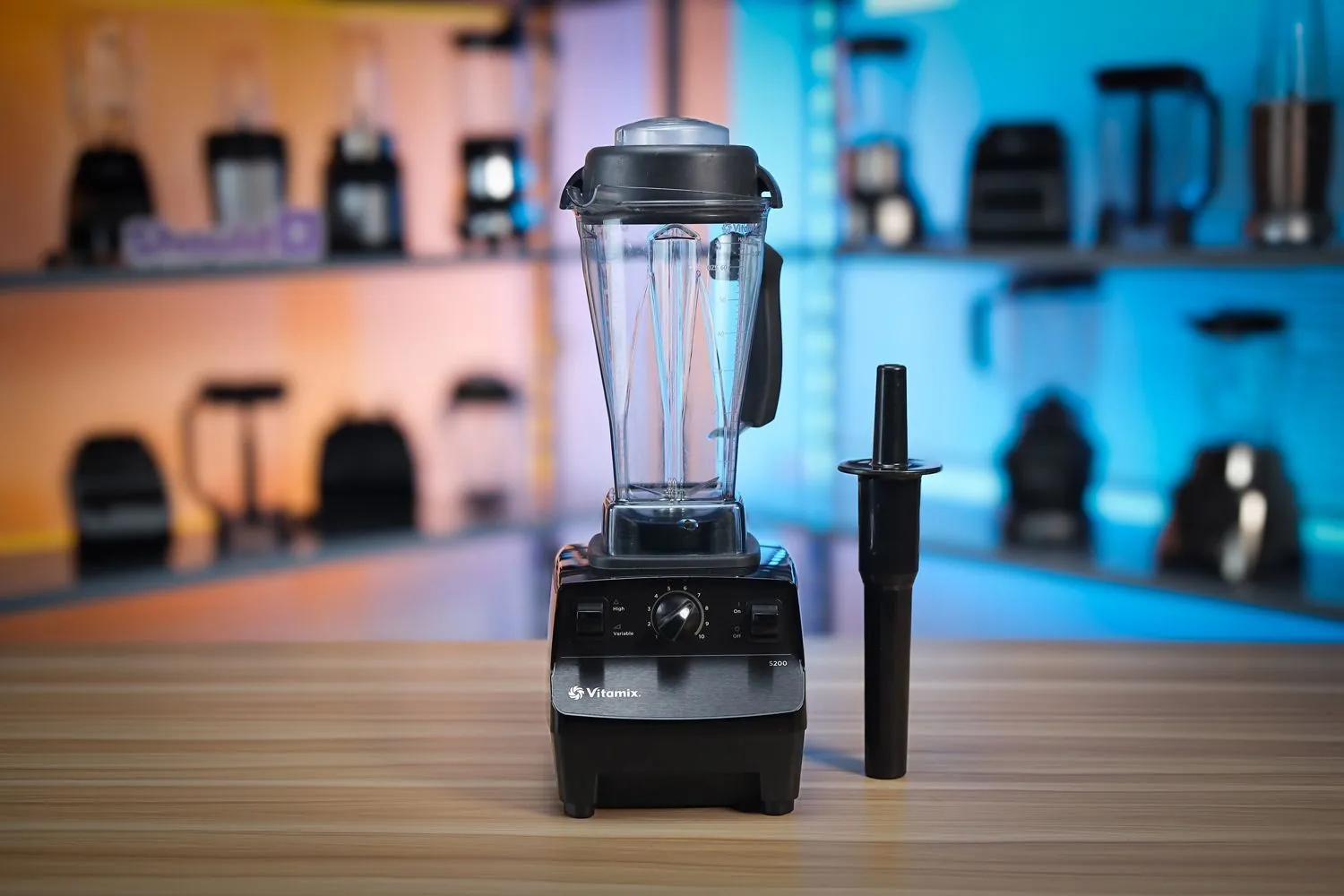 Hands carefully adjusting the speed dial on a Vitamix blender for safe operation.