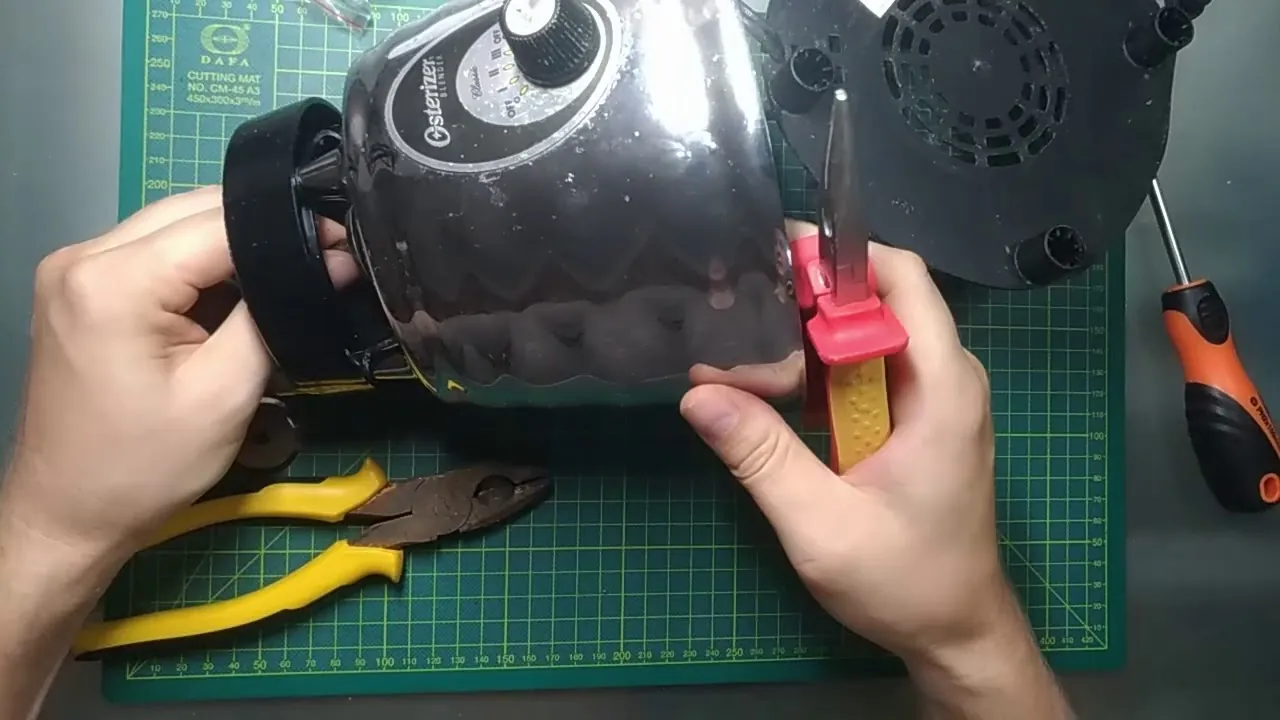 Hands carefully removing gasket from Oster blender blade assembly