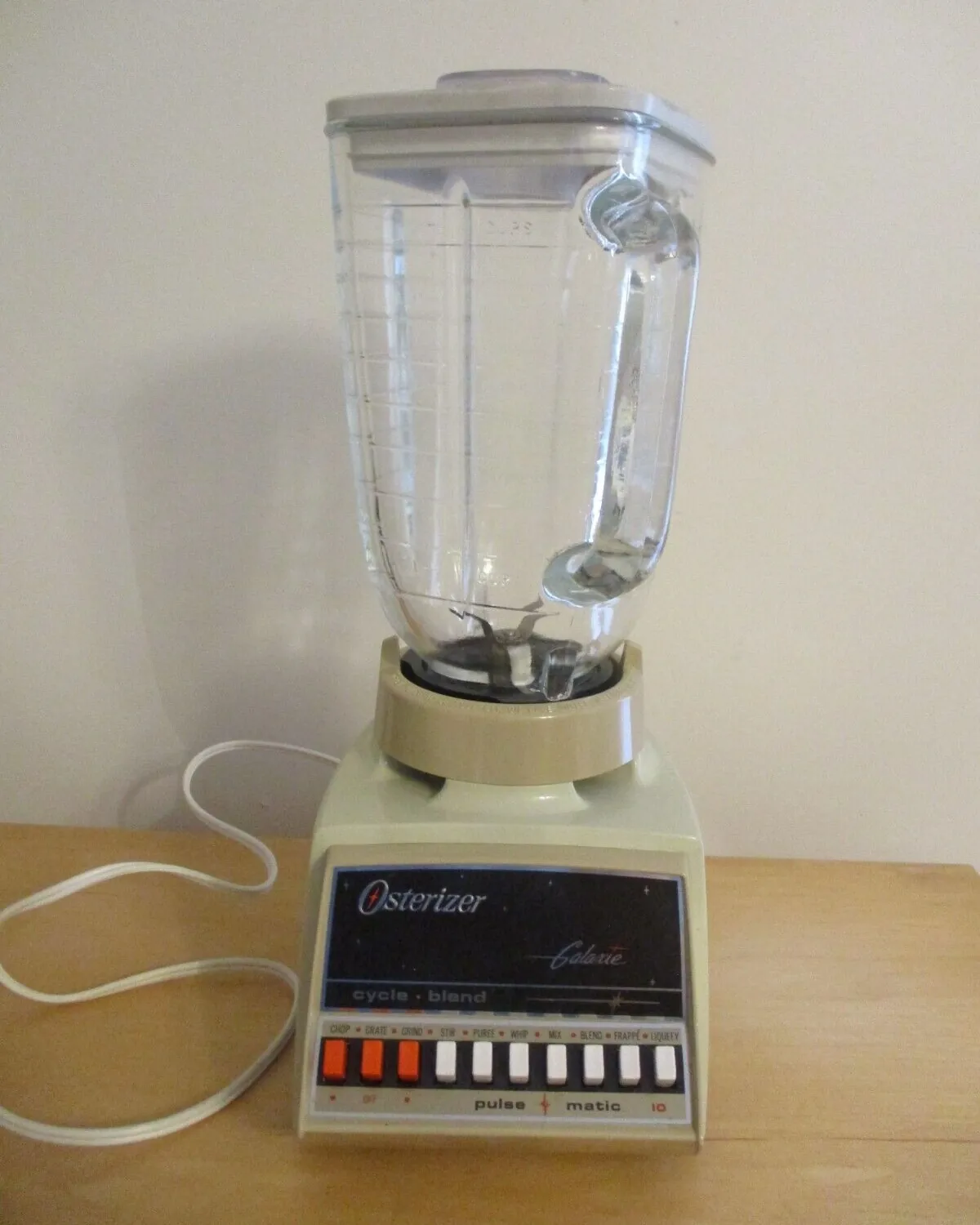 Hands inspecting the base label of an old Osterizer blender on a counter