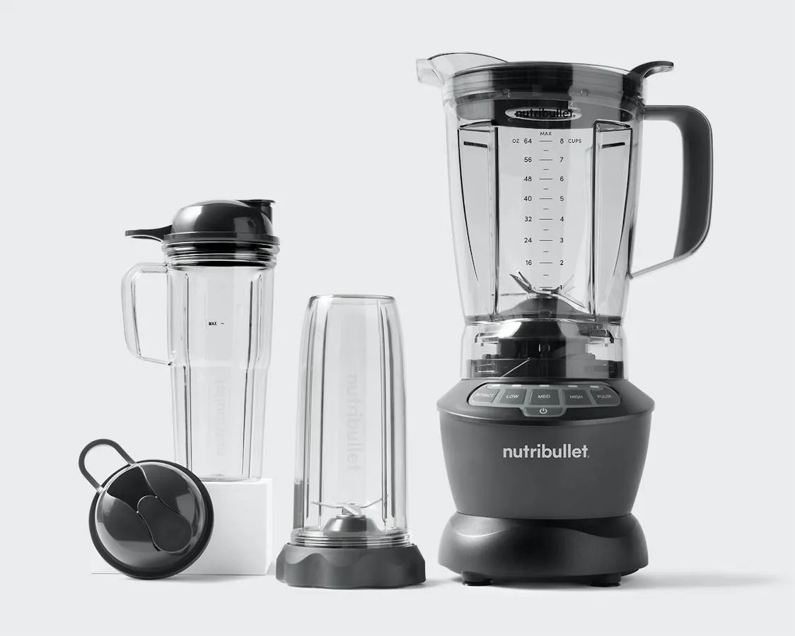 Hands rinsing Nutribullet cup and blade base under warm water