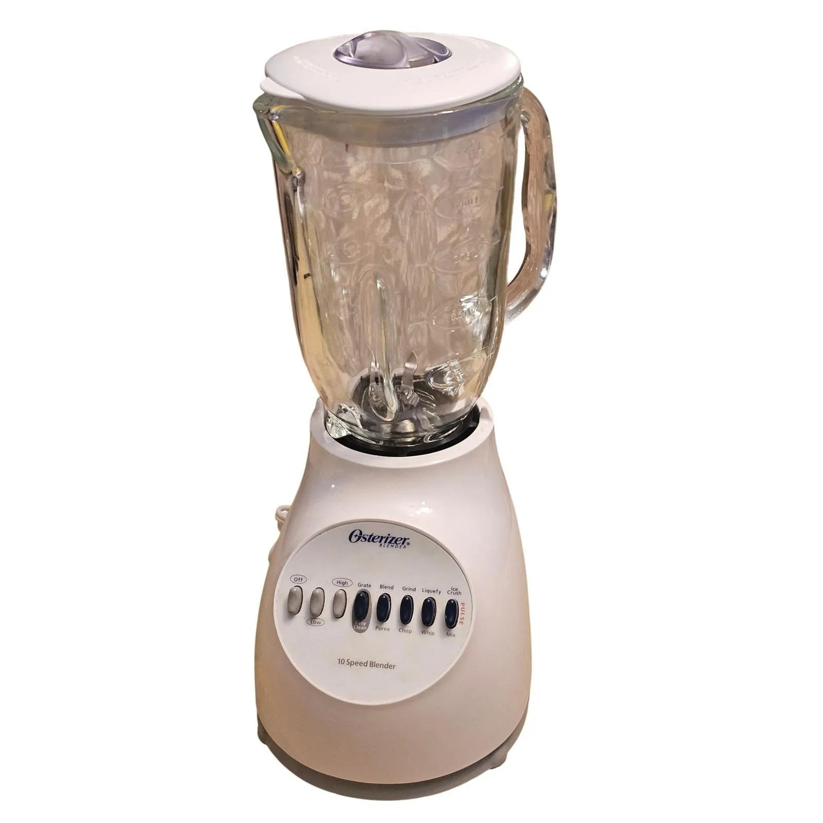 Hands selecting a speed on a vintage Osterizer blender filled with smoothie