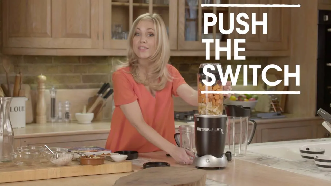 Hands twisting a blender cup into the motor base to start it