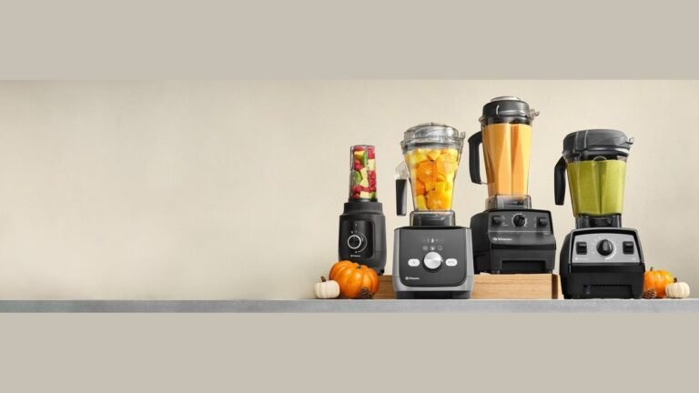 A high-performance blender sits on a marble countertop in a bright modern kitchen.