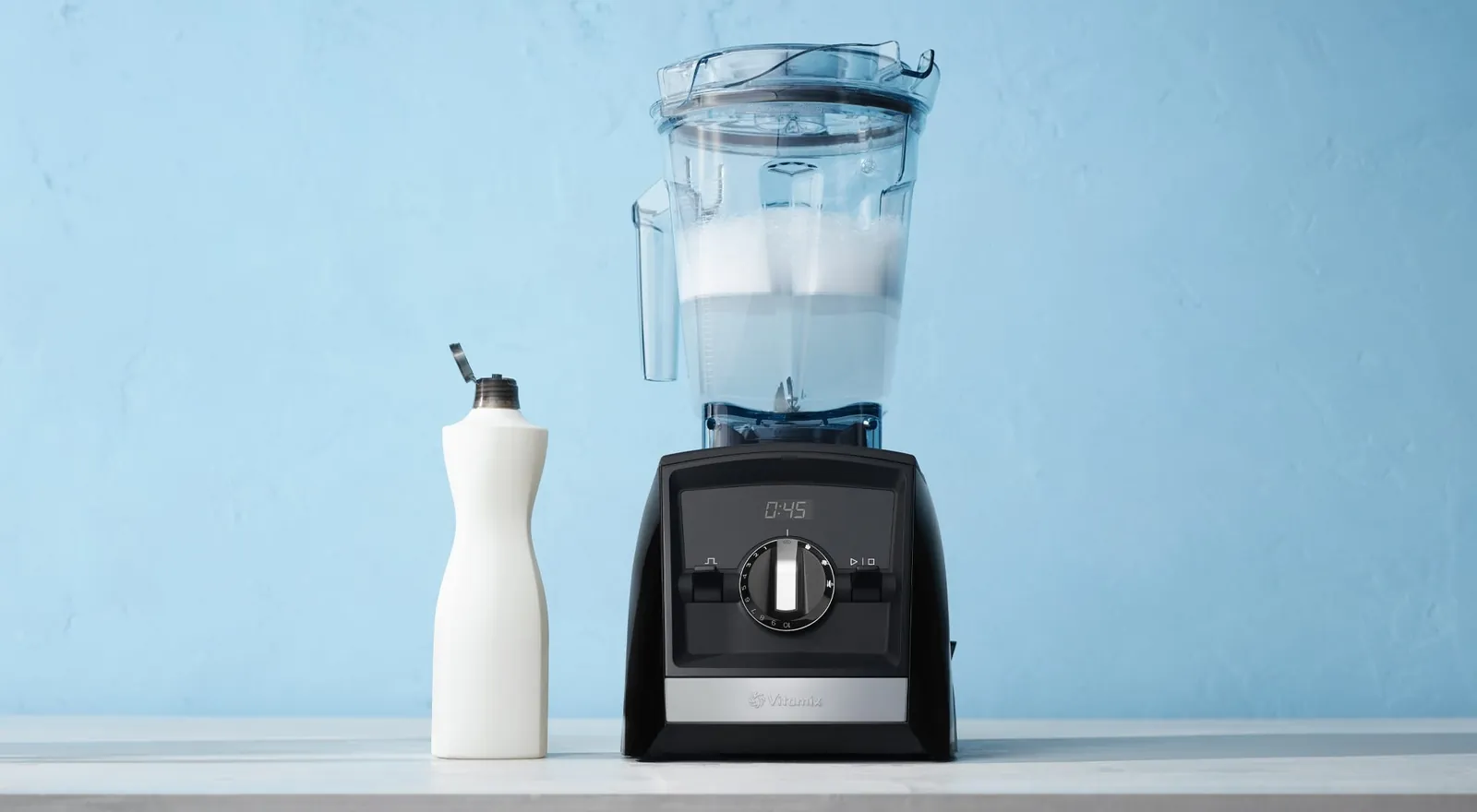 Home cook examining whetstone next to Vitamix blade unit on kitchen counter