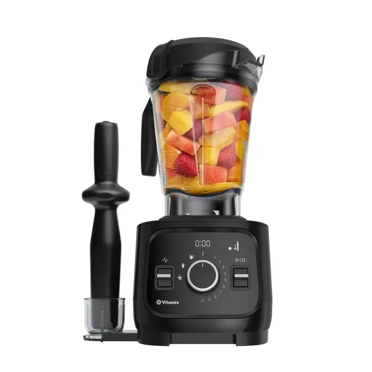 A masticating juicer extracts juice while separating dry fiber on a kitchen counter.