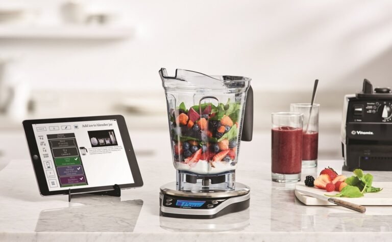 A modern kitchen setup featuring a smart scale and blender for recipe tracking.