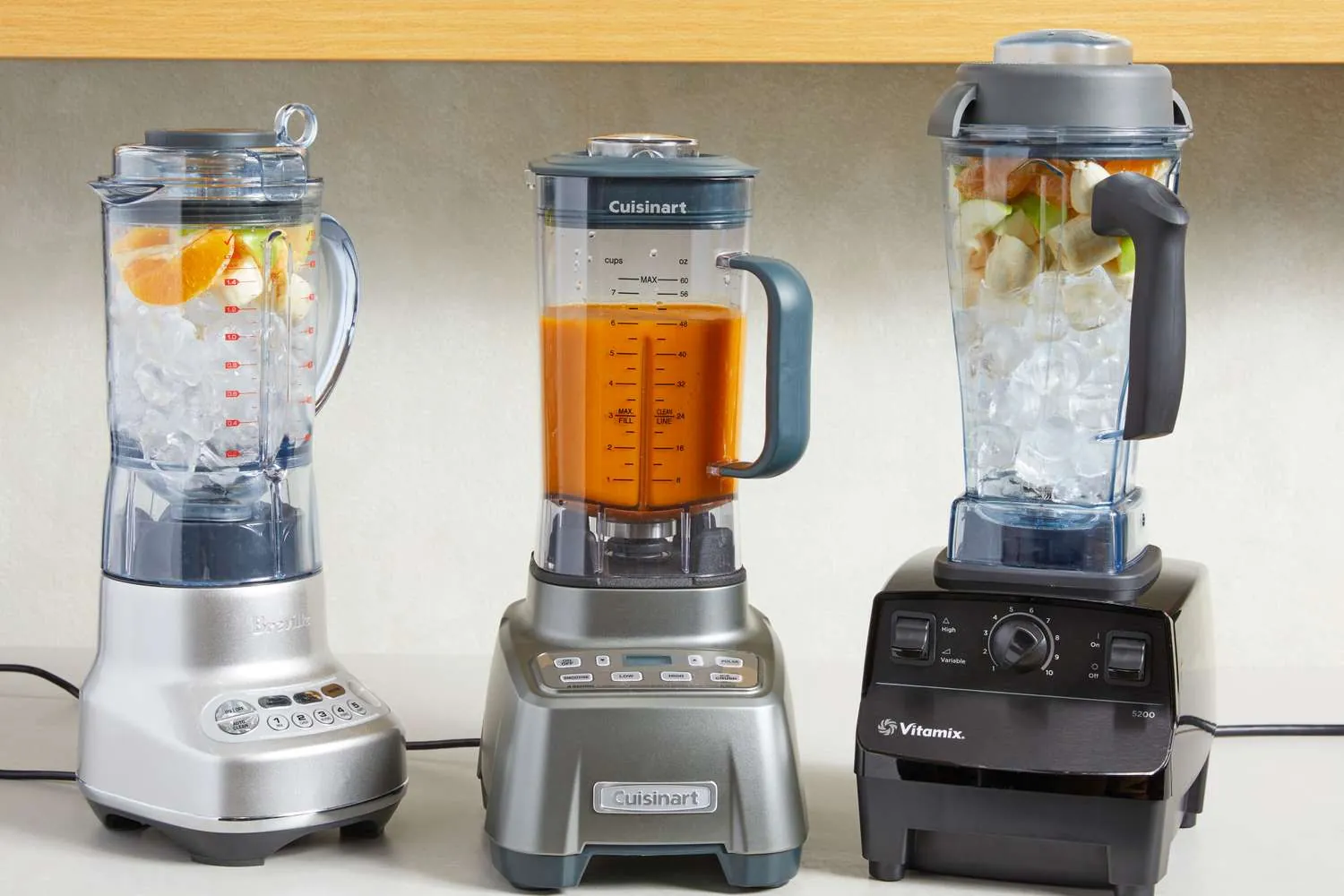 Mother serving smoothies to family in bright modern kitchen