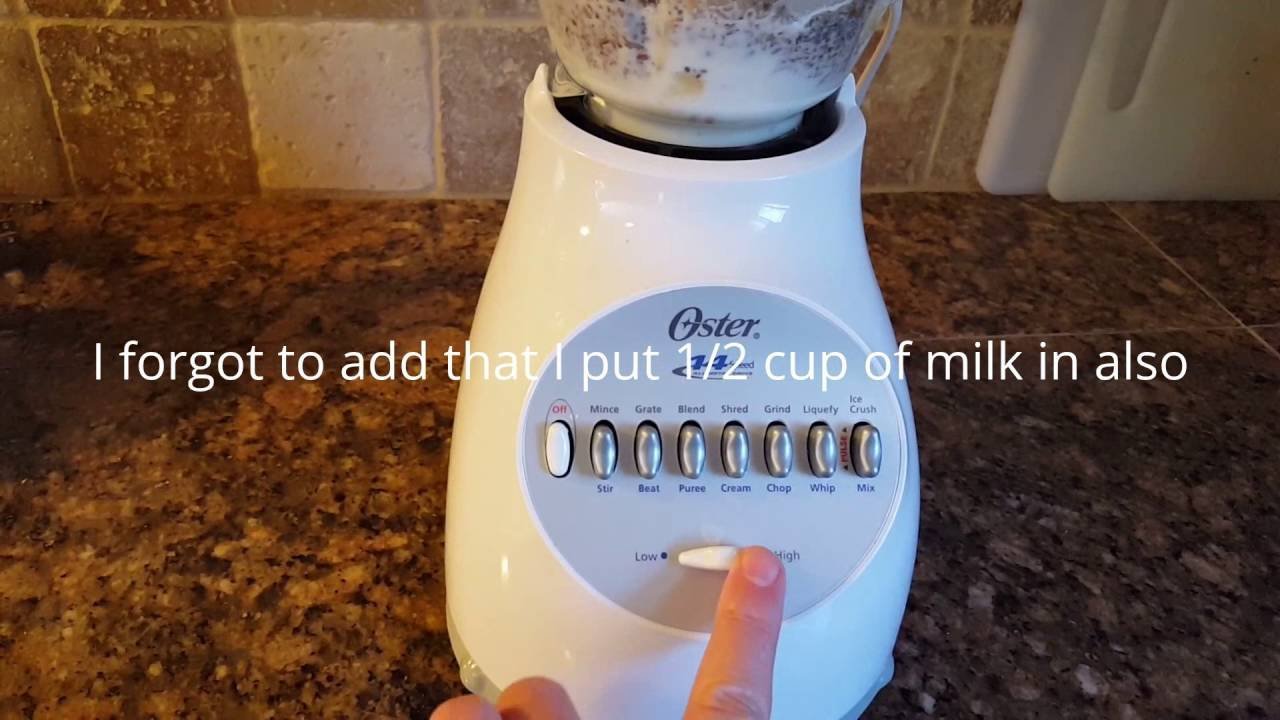 Oster 14-speed blender on kitchen counter with fruit smoothie