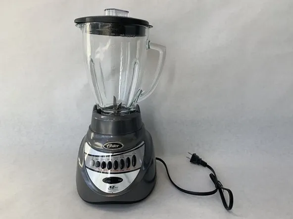 Oster blender with lid ajar beside a plugged-in wall outlet