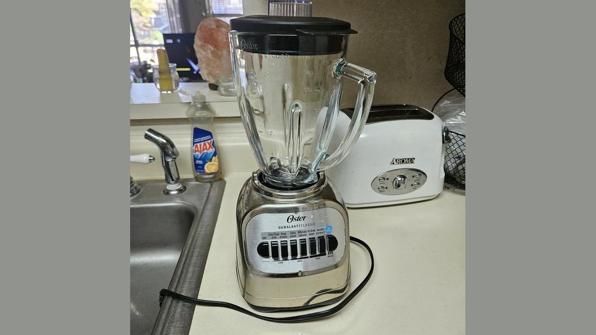 Oster Duralast Classic blender on kitchen counter with fruit smoothie