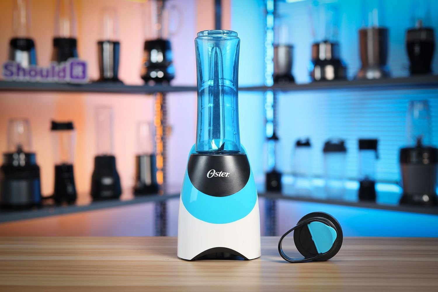 Oster personal blender on a kitchen counter with fresh berries nearby