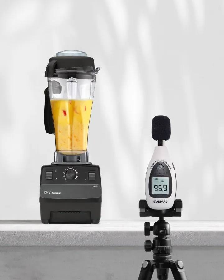 A person stands in a quiet kitchen next to a blender near a nursery.