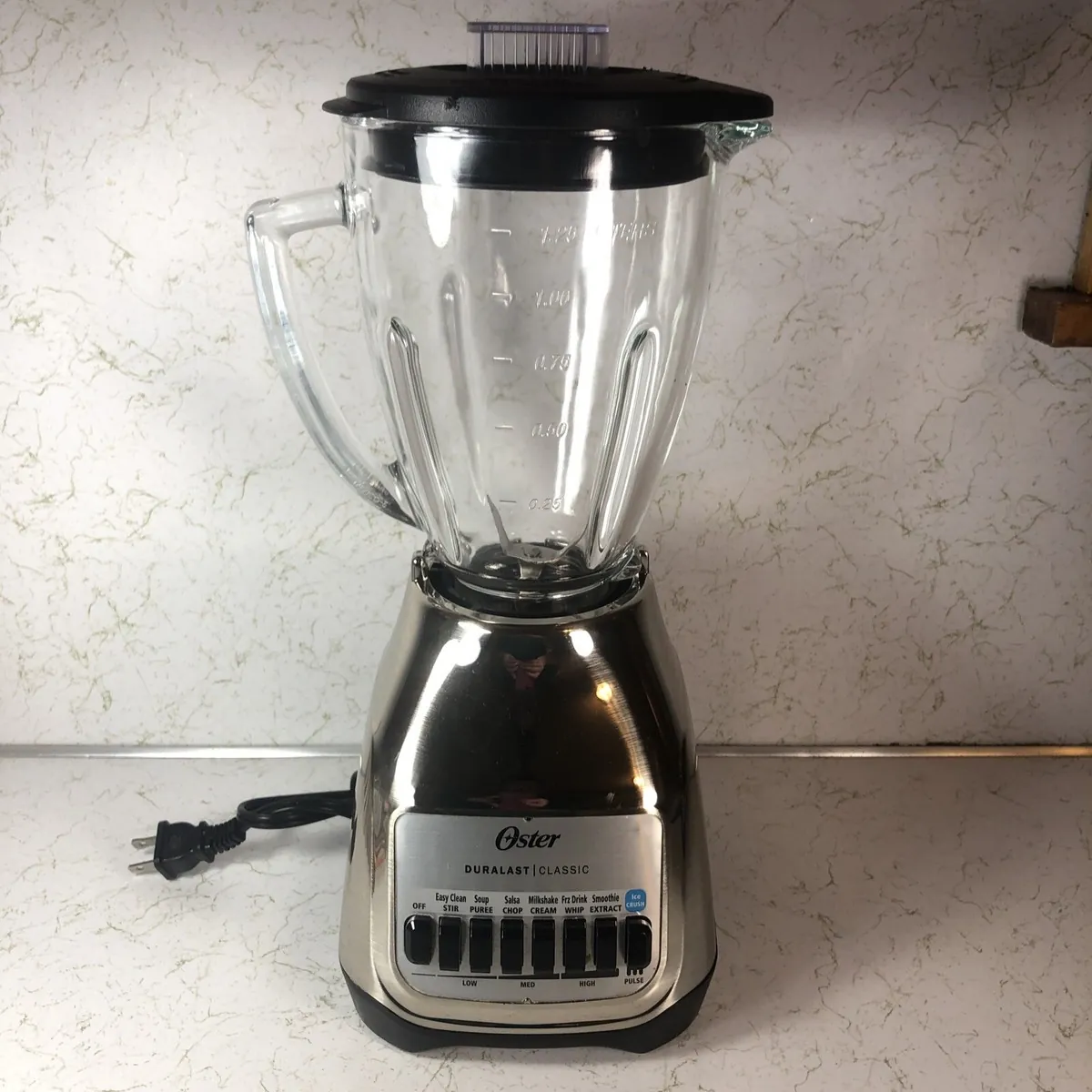 Person unboxing new Oster Duralast blender in bright kitchen