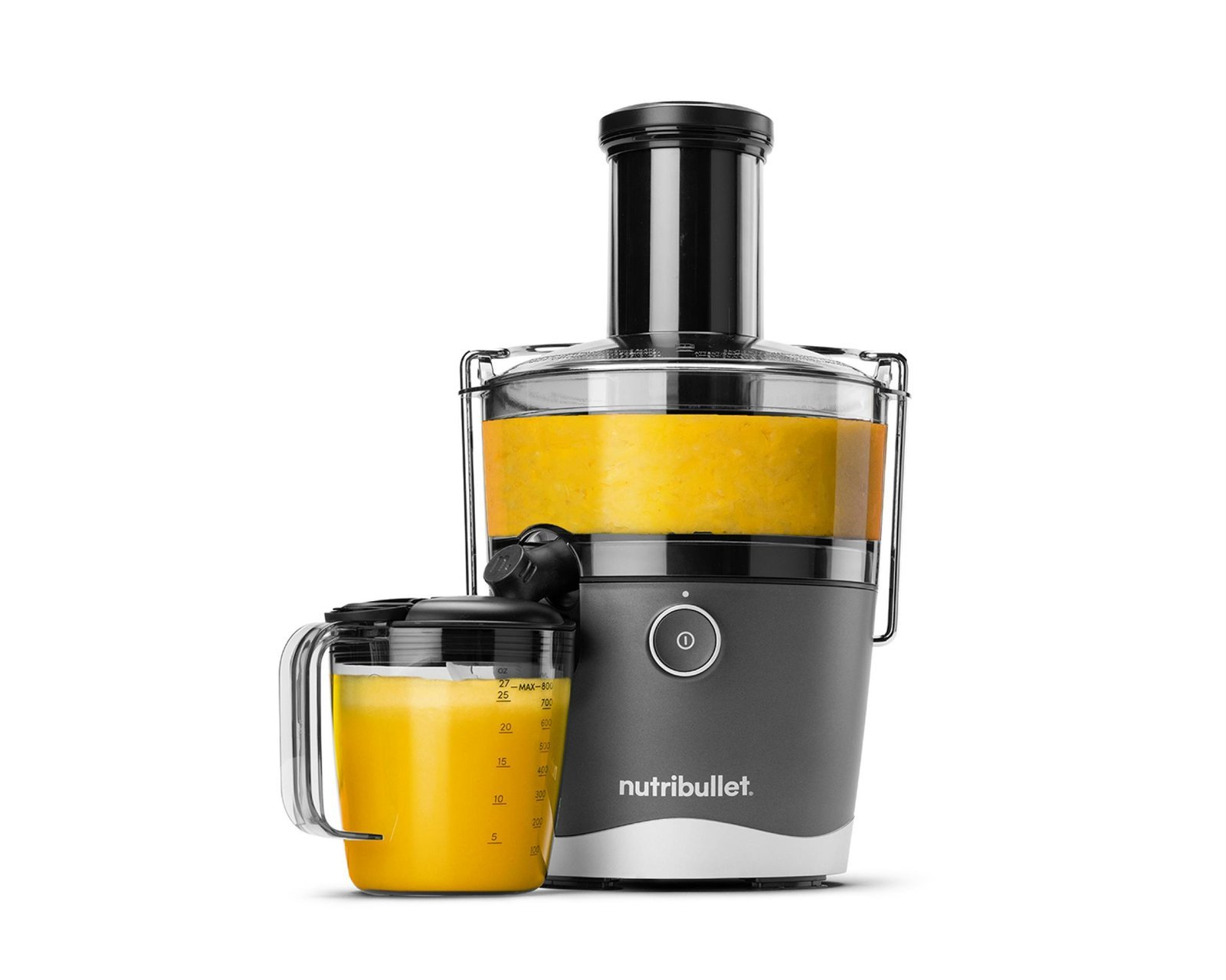 Personal blender with green juice and fresh vegetables on a kitchen counter