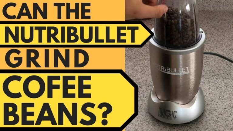 Personal blender on a kitchen counter with coffee beans and grounds