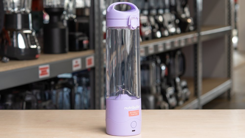 Portable blender filled with berry smoothie on a kitchen counter