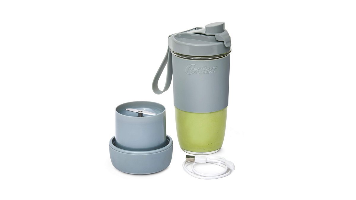 Portable blender with green smoothie on a kitchen counter