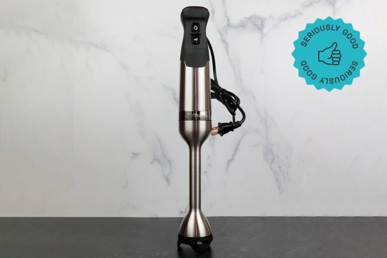 A premium Vitamix immersion blender sits on a marble counter ready for culinary tasks.