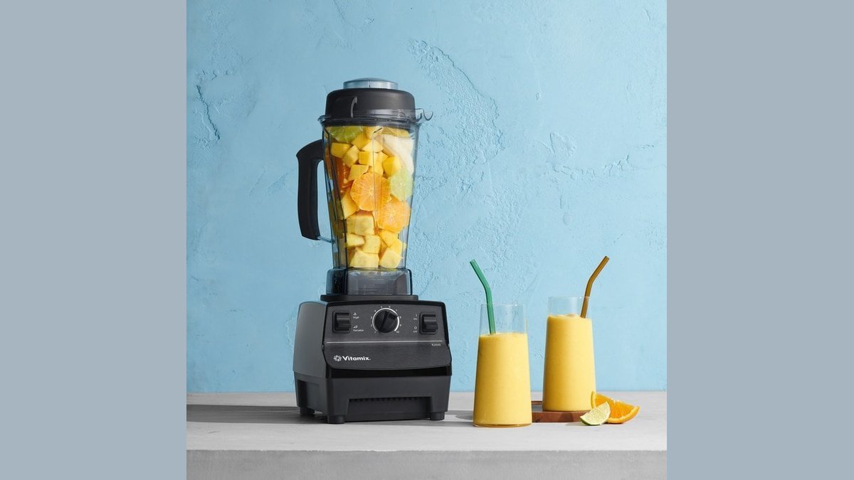 A professional Vitamix 5200 blender displayed on a clean kitchen counter with fresh ingredients.