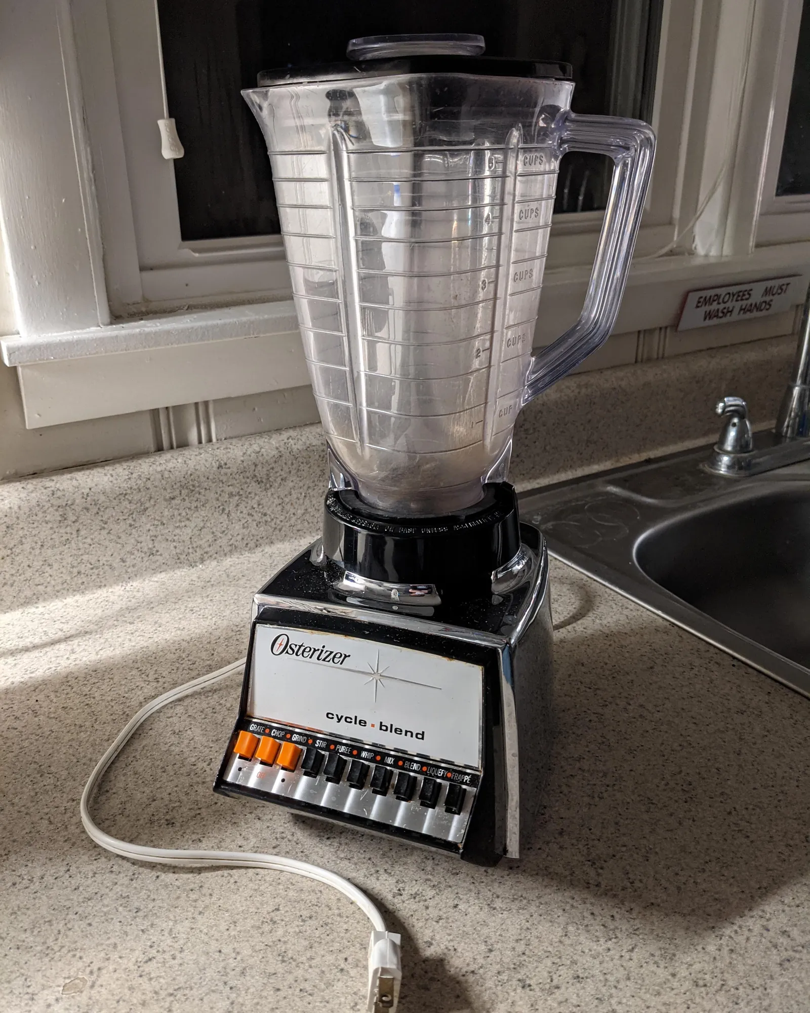 Unlabeled old blender with frayed cord on a workbench for photo documentation