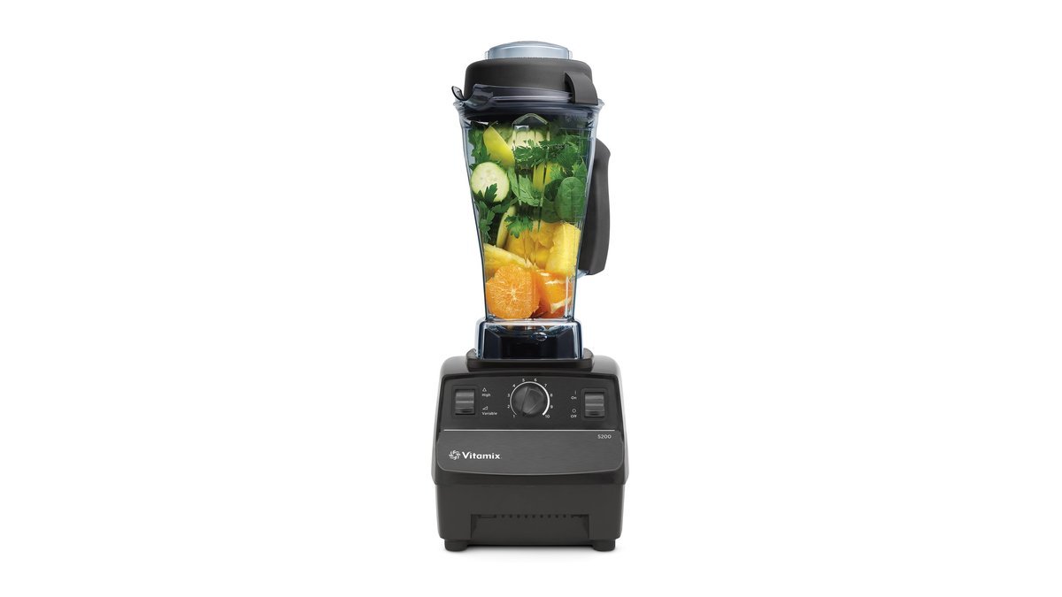 The Vitamix 5200 blender sits ready on a modern kitchen counter with fresh ingredients.