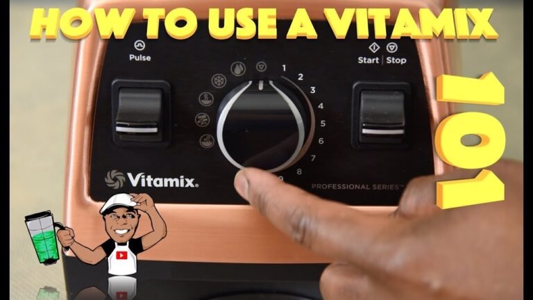Vitamix blender with low-profile container blending almond butter on a marble countertop in natural light.