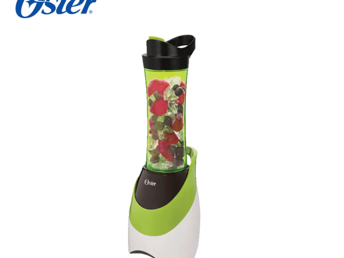 Woman standing beside her Oster personal blender on a kitchen counter
